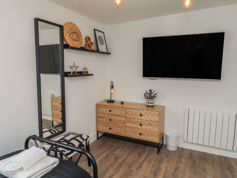 A bedroom with a mirror and television at Summerset Lodge in Bamburgh