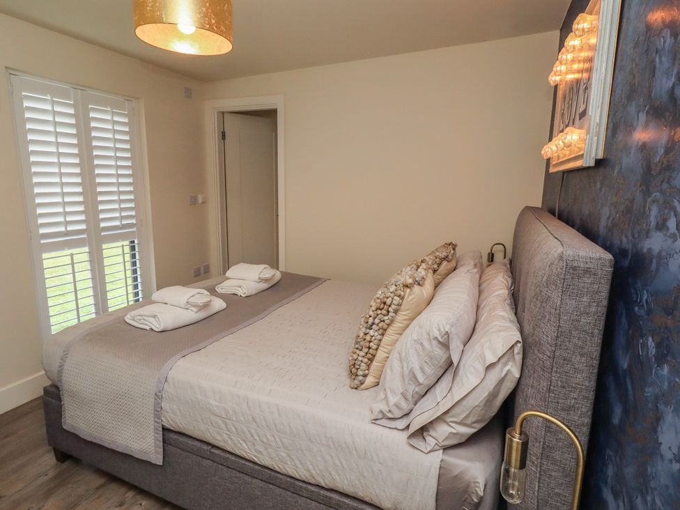 A bedroom with a bed and bedside lamp at Summerset Lodge in Bamburgh