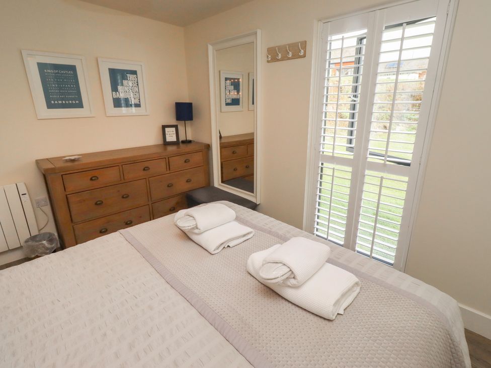 A bedroom with a bed and a dresser at Summerset Lodge in Bamburgh