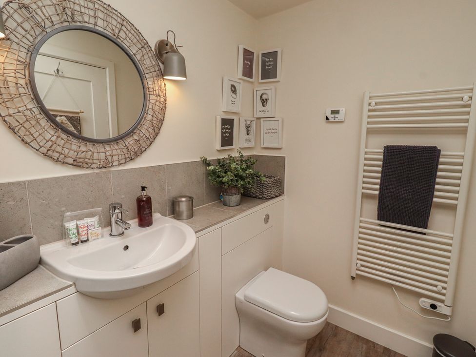 A bathroom with washbasin, mirror, and towel radiator at Summerset Lodge in Bamburgh