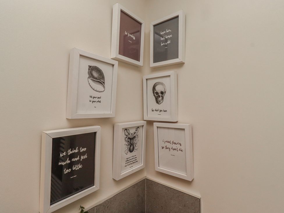 A collection of framed art on a wall at Summerset Lodge in Bamburgh