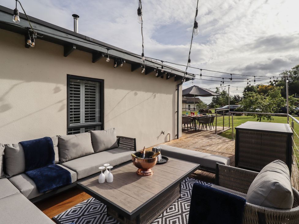 An outdoor patio with seating and table at Summerset Lodge in Bamburgh