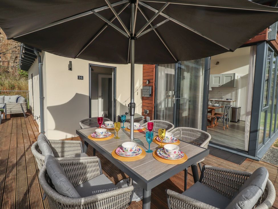 A dining table with chairs and umbrella at Summerset Lodge Bamburgh