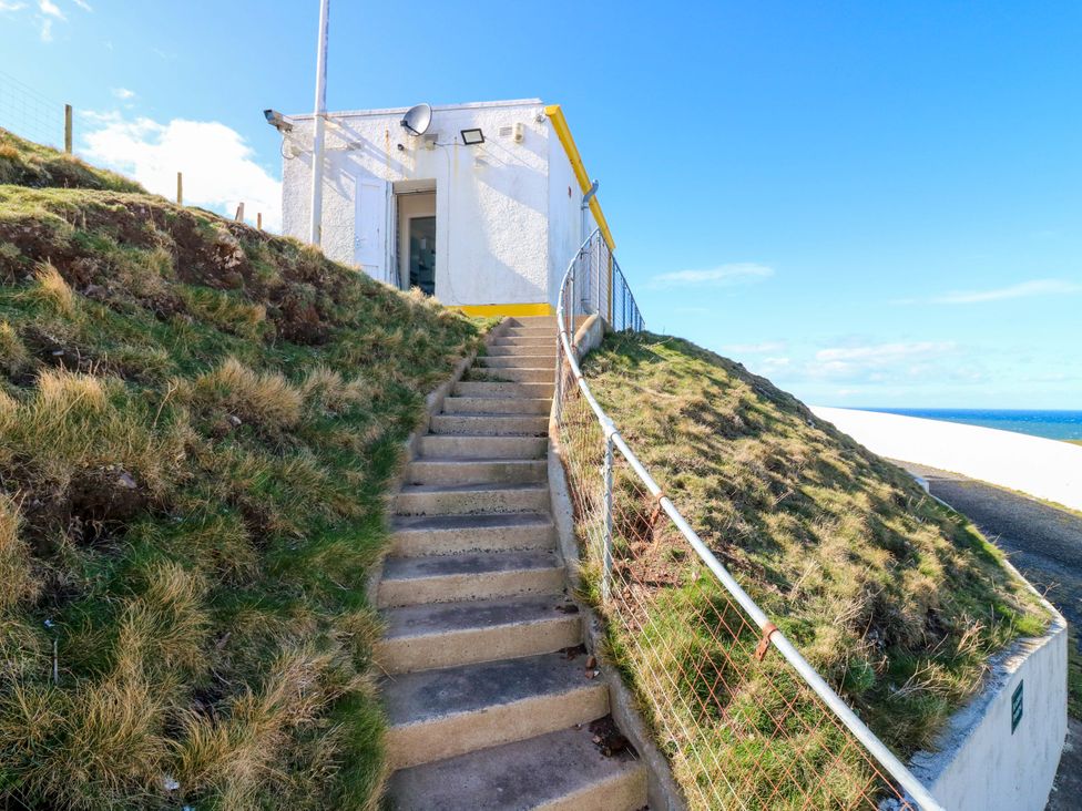 A building with stairs and a fence at The Flaghouse at The Lighthouse St Abbs