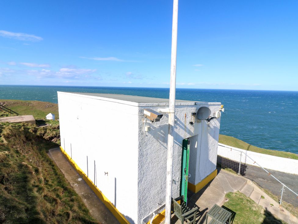A white building near the ocean at The Flaghouse at The Lighthouse St Abbs