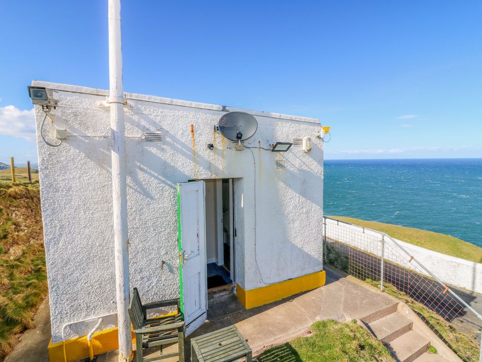 A building exterior with a door and satellite dish at The Flaghouse at The Lighthouse St Abbs