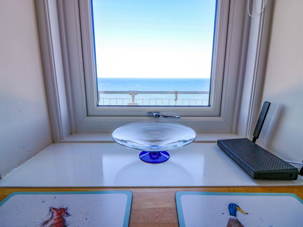 A kitchen window view showing the sea with a decorative plate and router at The Flaghouse at The Lighthouse St Abbs