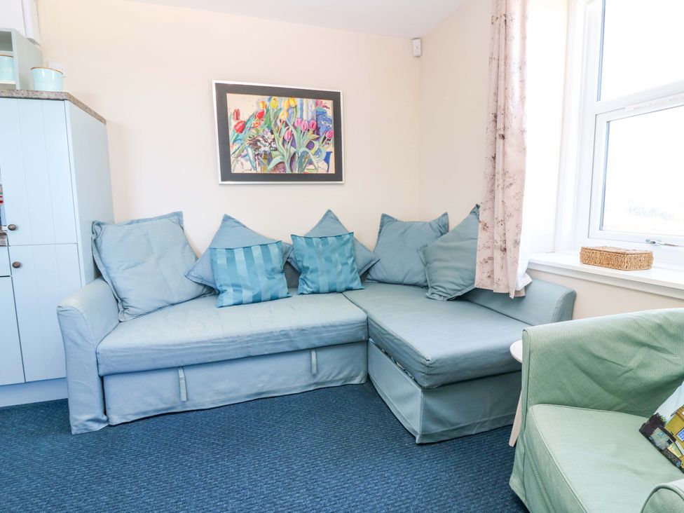 A living room with a couch and cushions at The Flaghouse at The Lighthouse St Abbs