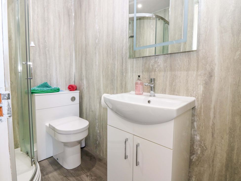 A bathroom with a shower, toilet, and sink at The Flaghouse at The Lighthouse St Abbs