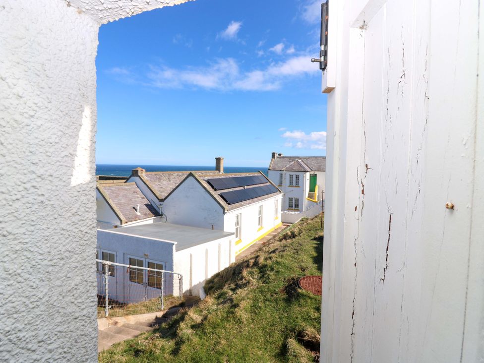View of houses and ocean from an outdoor area at The Flaghouse at The Lighthouse St Abbs