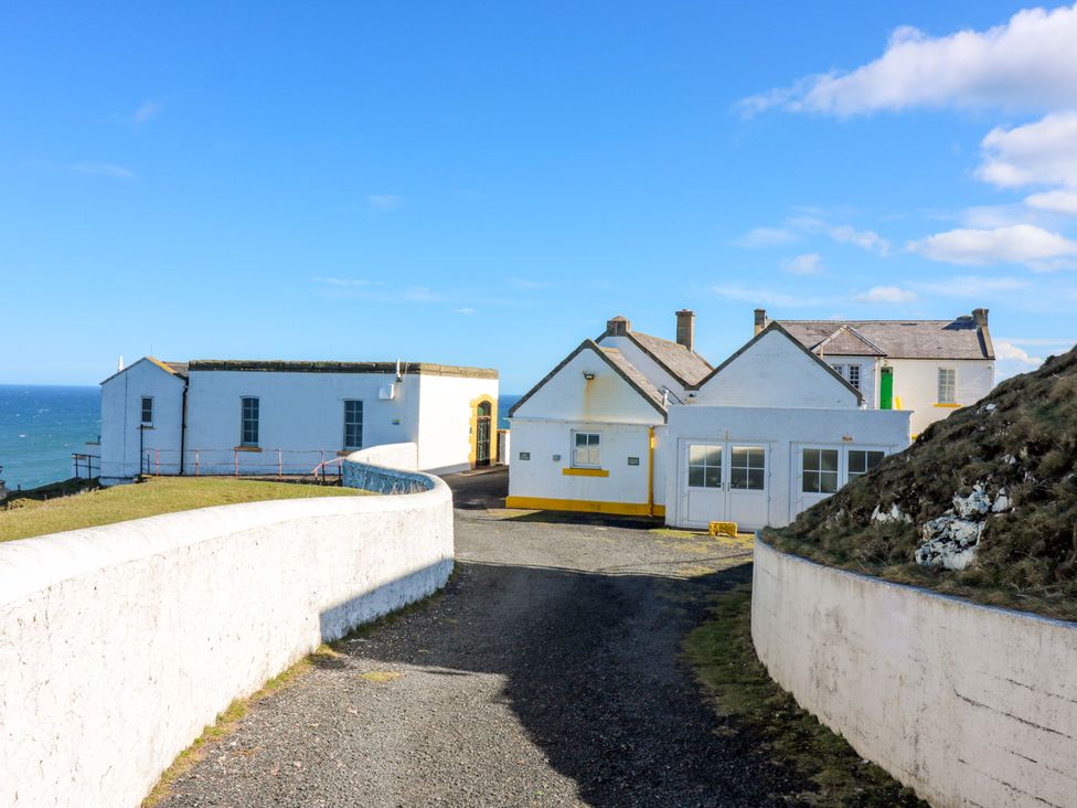 A building with a road leading to the ocean at The Flaghouse at The Lighthouse St Abbs