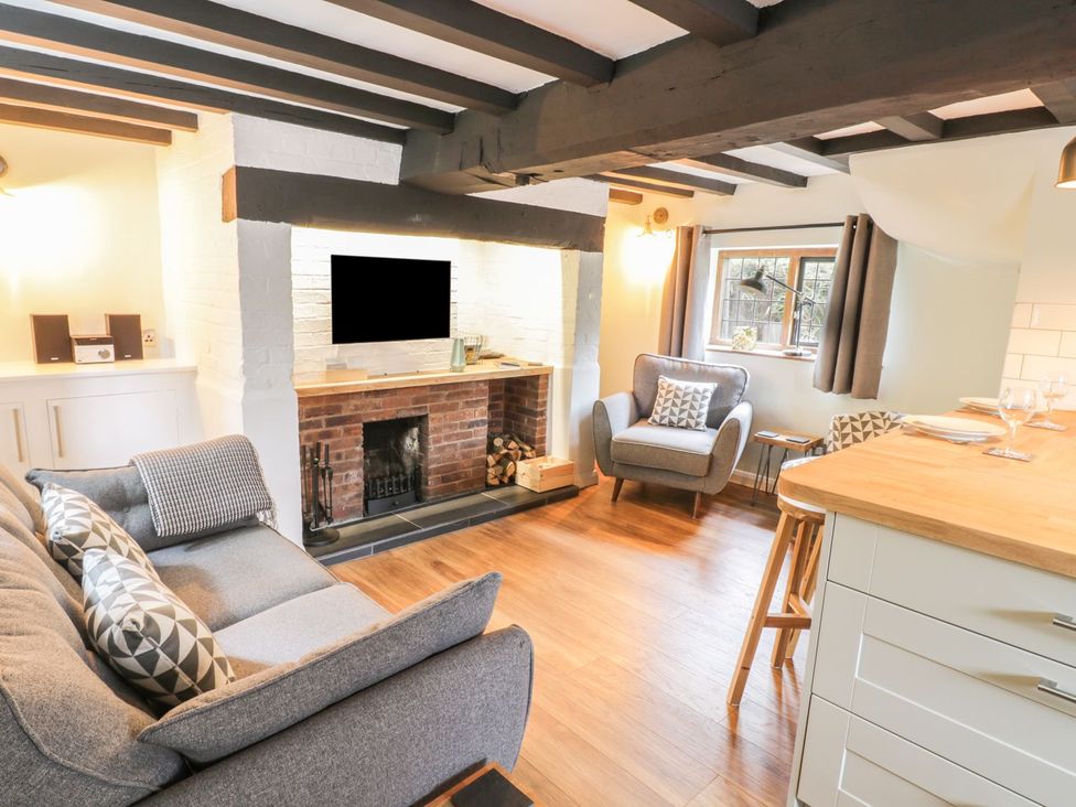 A living room with a sofa and fireplace at 4 Masons Court in Stratford-upon-Avon
