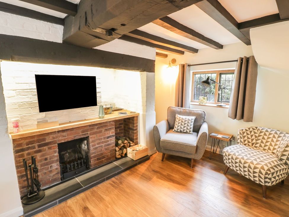A living room with a fireplace and two armchairs at 4 Masons Court Stratford-upon-Avon