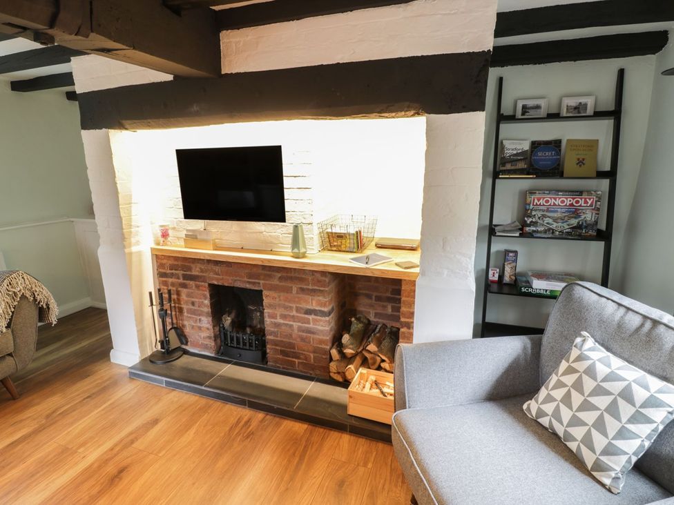 A living room with a fireplace and TV at 4 Masons Court in Stratford-upon-Avon