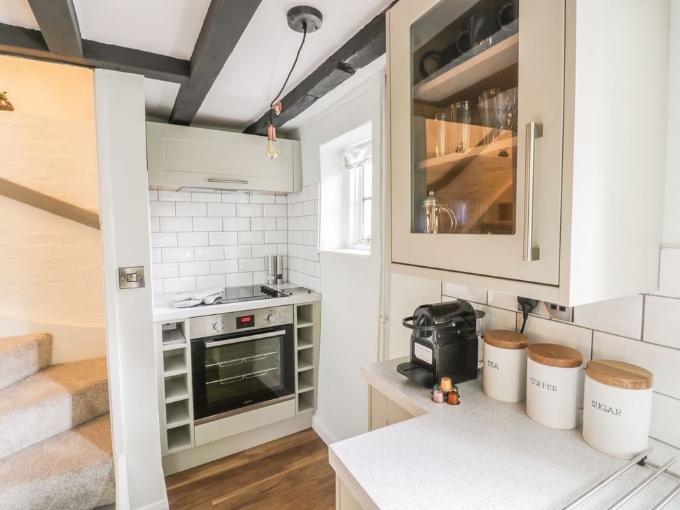 A kitchen with stove and storage jars at 4 Masons Court in Stratford-upon-Avon