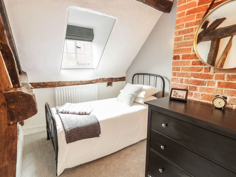 A bedroom with a bed and dresser at 4 Masons Court Stratford-upon-Avon