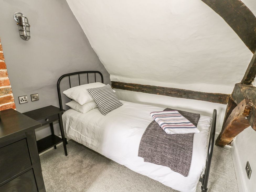 A bedroom with a single bed and bedside table at 4 Masons Court in Stratford-upon-Avon