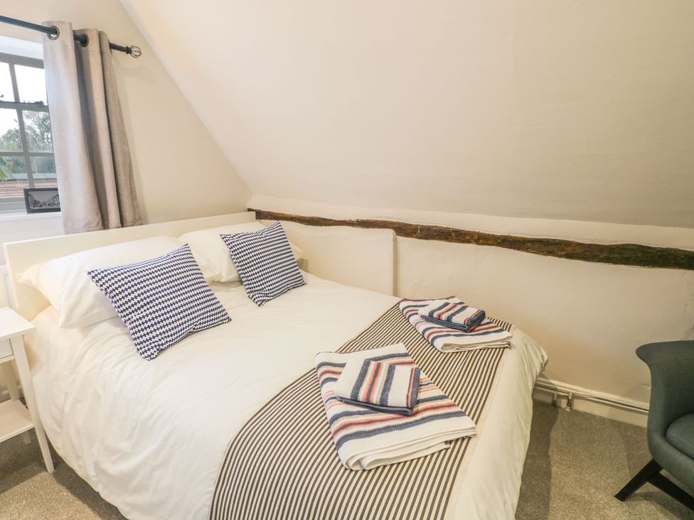 A bedroom with a bed and towels at 4 Masons Court in Stratford-upon-Avon
