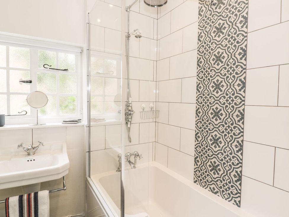 A bathroom with a shower and bathtub at 4 Masons Court in Stratford-upon-Avon