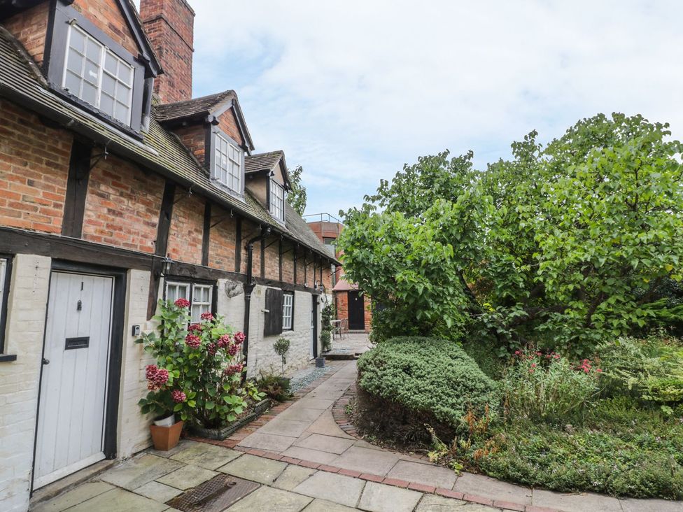 A garden with a pathway and trees at 4 Masons Court Stratford-upon-Avon