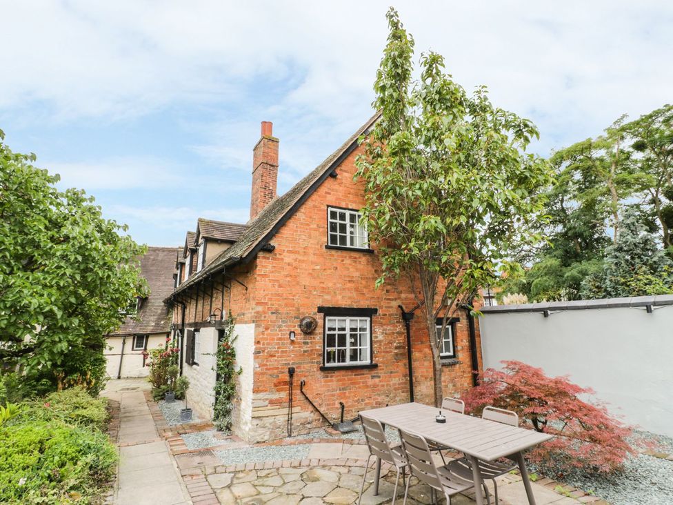 A house with a garden table and chairs at 4 Masons Court in Stratford-upon-Avon