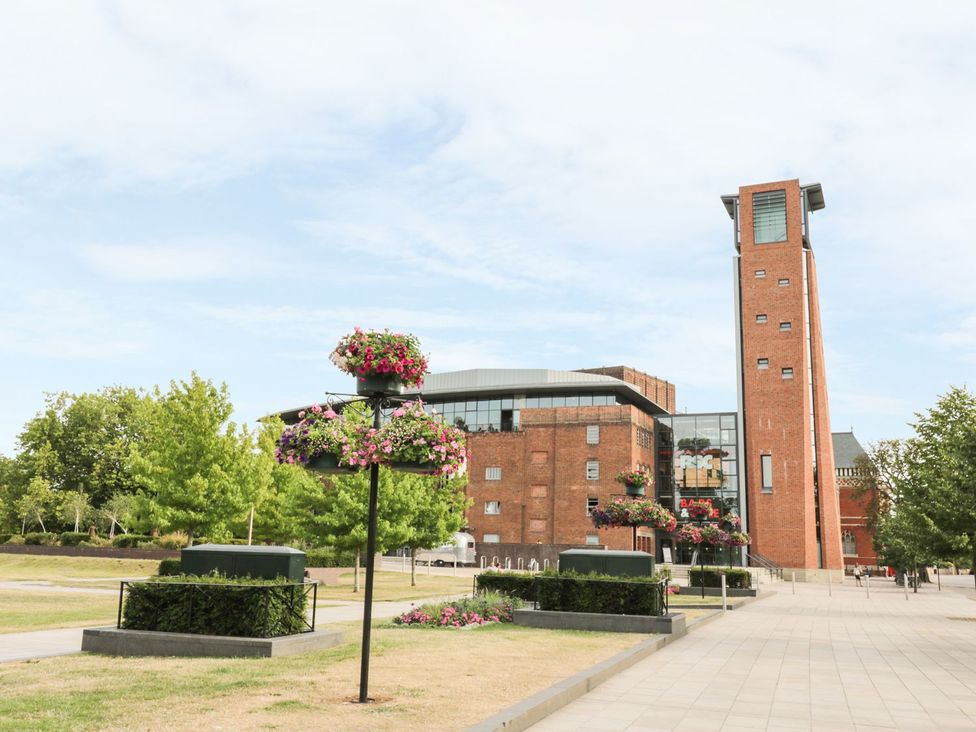 An outdoor area with a brick building and flower planters at 4 Masons Court in Stratford-upon-Avon