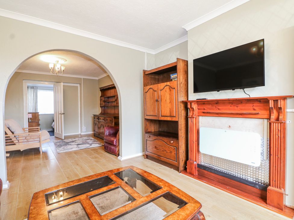 A living room with a table and sofa at The Retreat in Deal