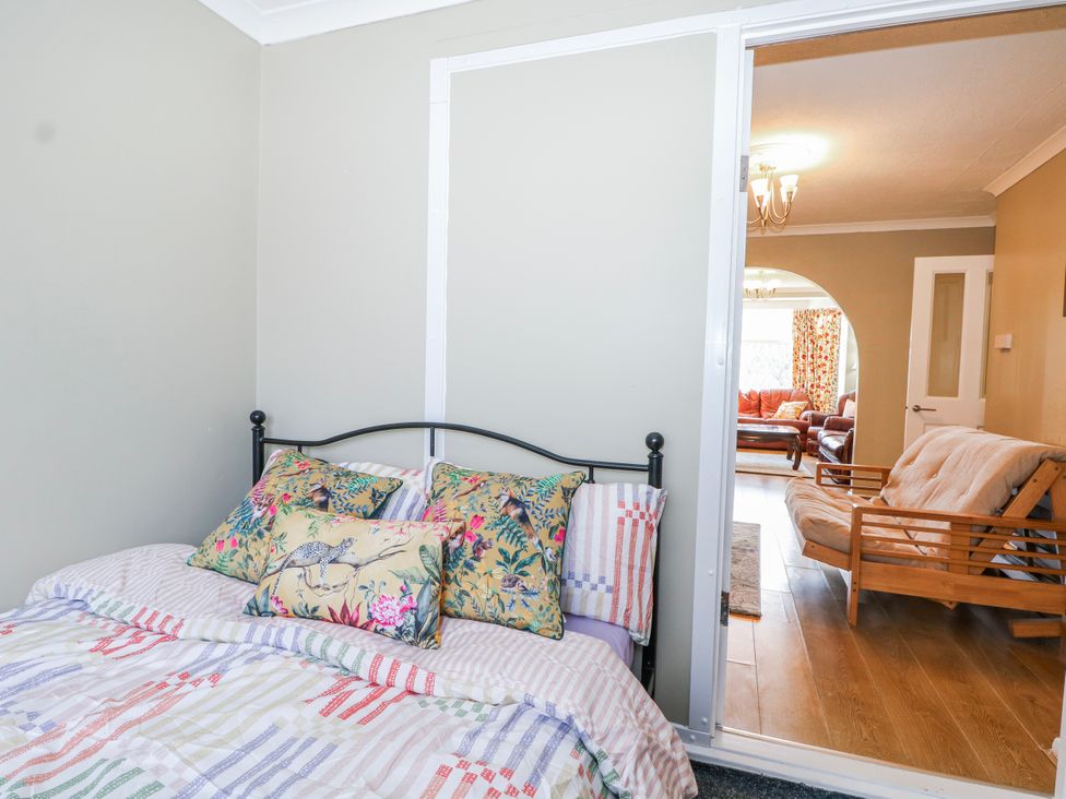 A bedroom with a bed and doorway leading to another room at The Retreat in Deal