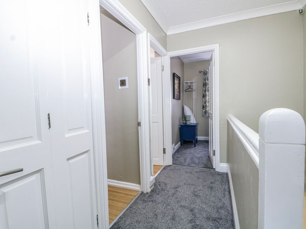 A hallway with doors and a coatrack at The Retreat in Deal