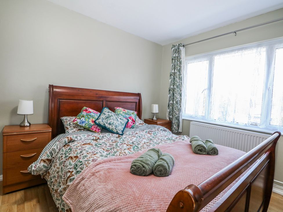 A bedroom with a bed and side table at The Retreat in Deal