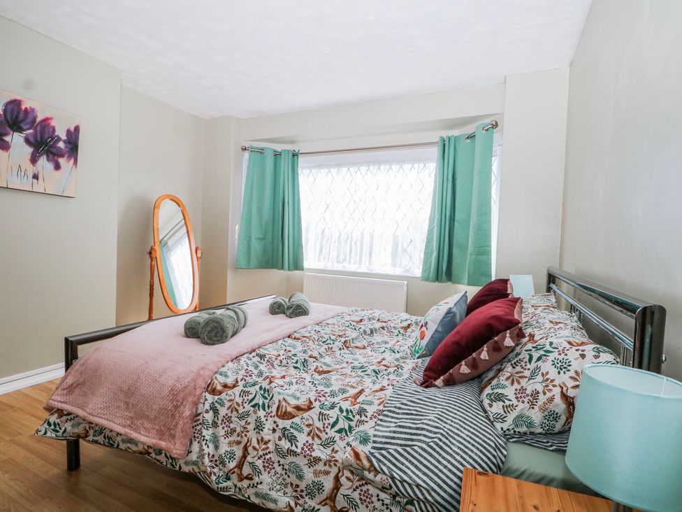 A bedroom with a bed, a mirror, and curtains at The Retreat in Deal