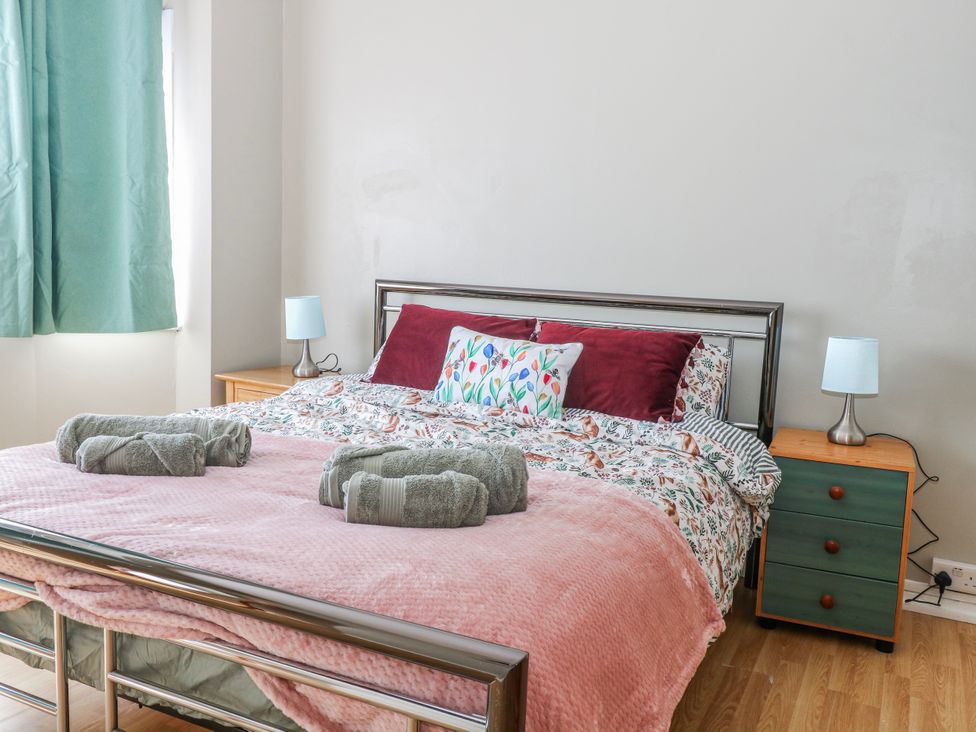 A bedroom with a bed and bedside table at The Retreat in Deal