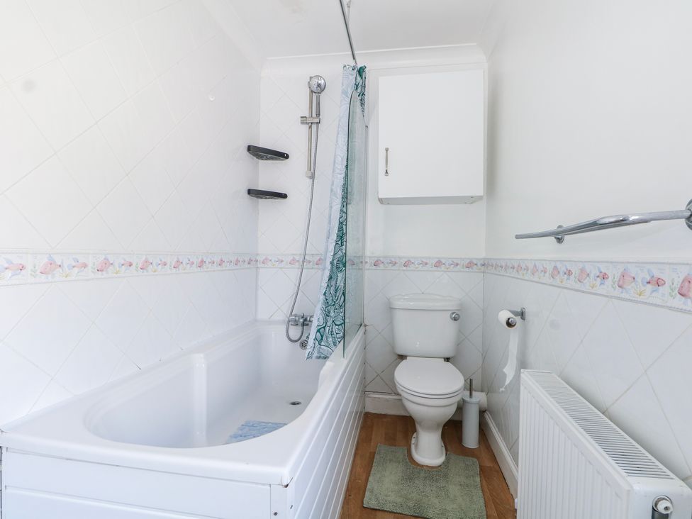 A bathroom with a bathtub and shower at The Retreat in Deal