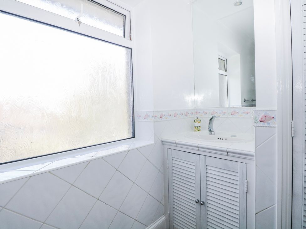 A bathroom with a sink and mirror at The Retreat in Deal