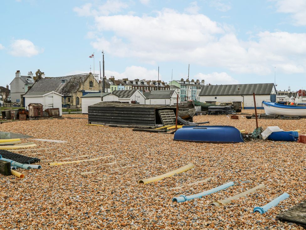 A view of a beach with boats and boathouses at The Retreat in Deal
