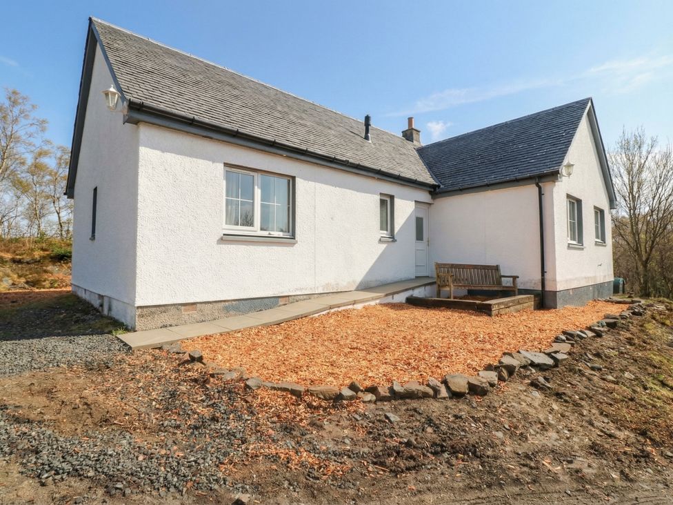 A house with a bench and gravel in an outdoor area at Doire An Daimh