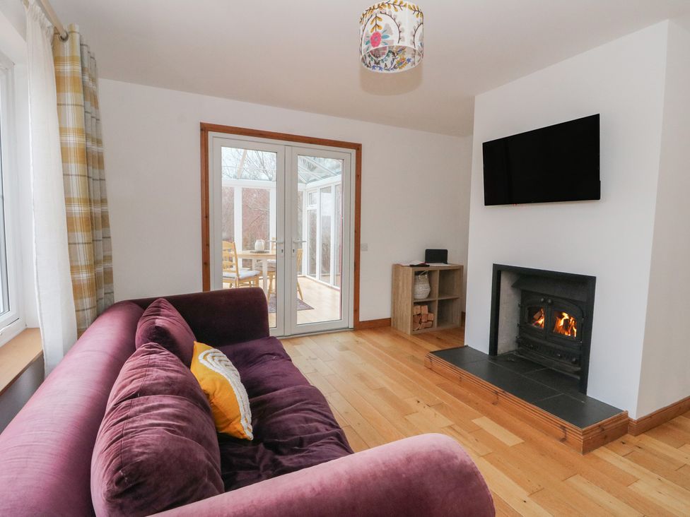 A living room with a fireplace and sliding doors at Doire An Daimh