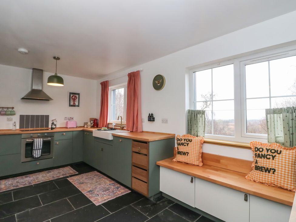 A kitchen with a sink and stove along with seating at Doire An Daimh