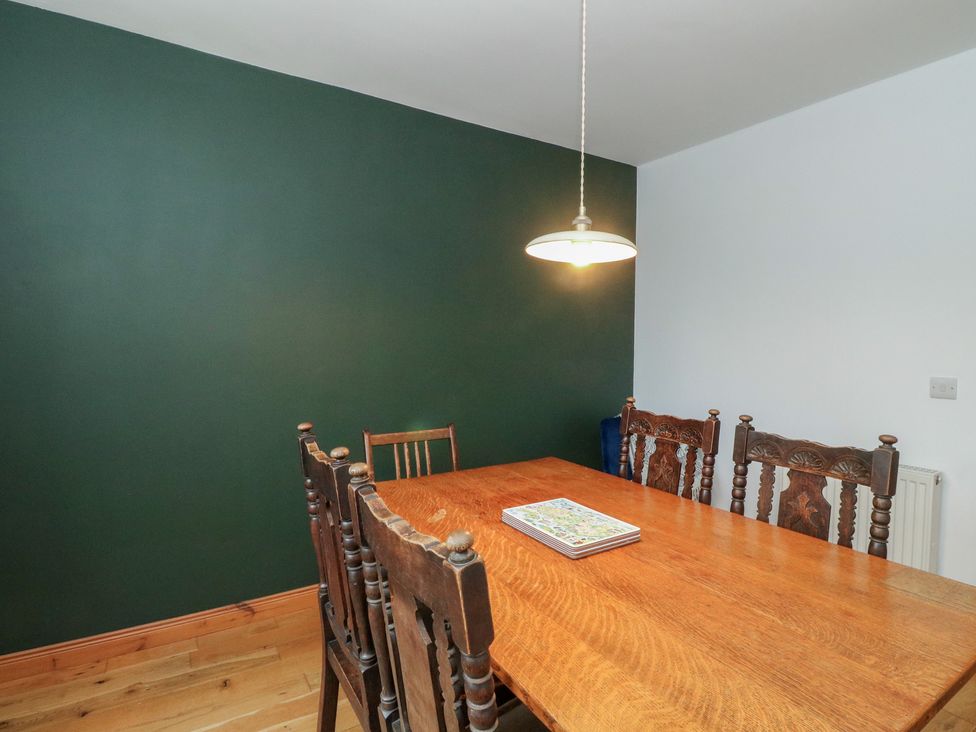 A dining room with a wooden table and chairs at Doire An Daimh