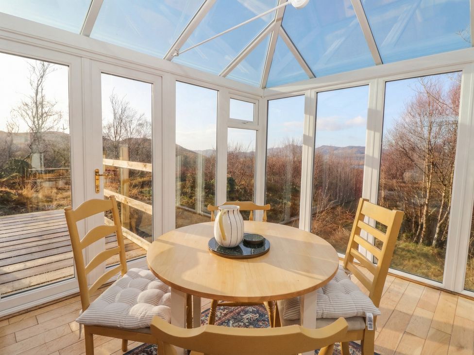 A conservatory with a table and chairs at Doire An Daimh