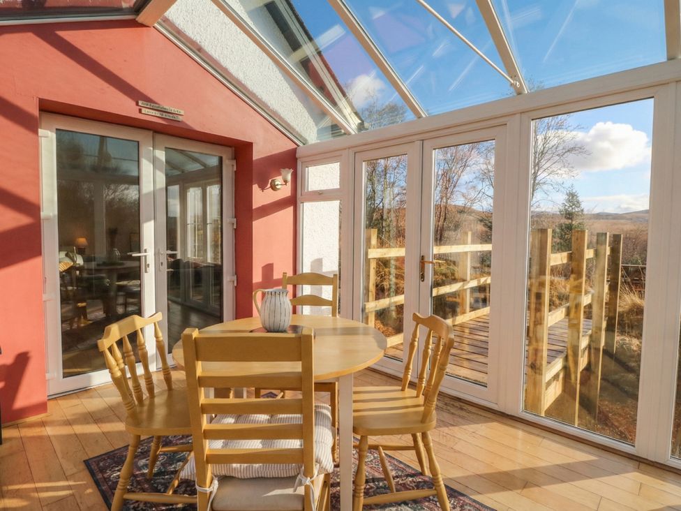 A conservatory with a table and chairs at Doire An Daimh