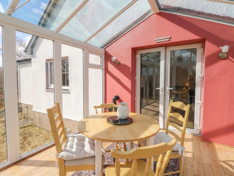 A conservatory with a table and chairs at Doire An Daimh