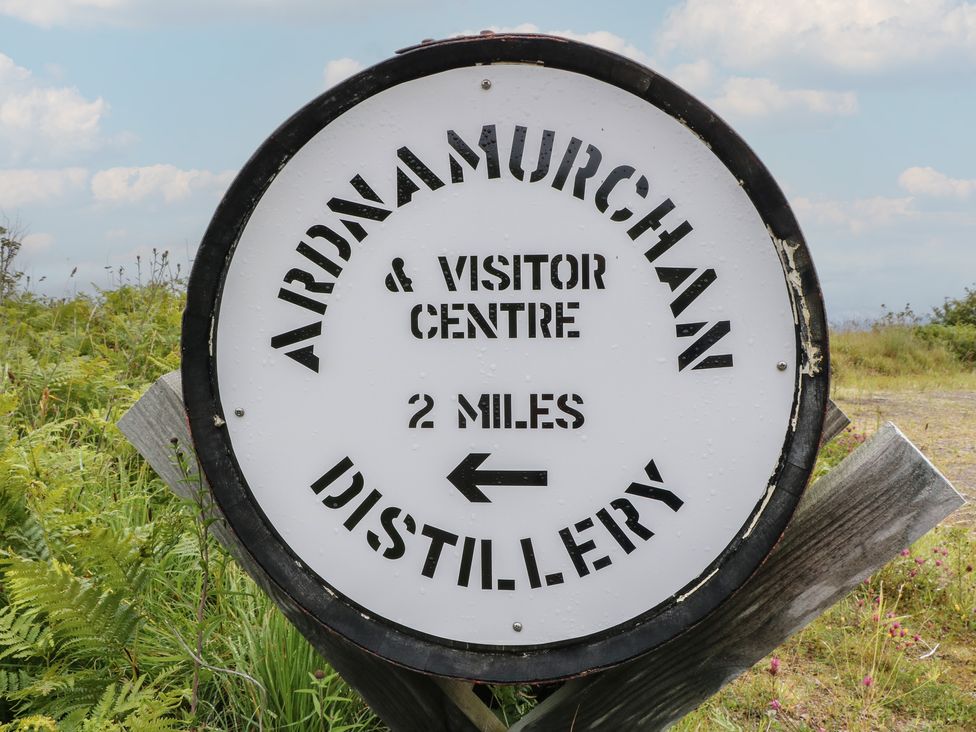 A sign indicating direction to Ardnadamurchan distillery and visitor centre 2 miles away