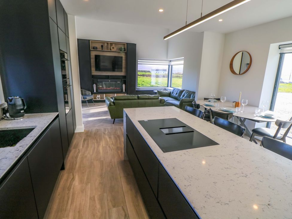 A kitchen with an island and dining area at An Tobar in Ballina