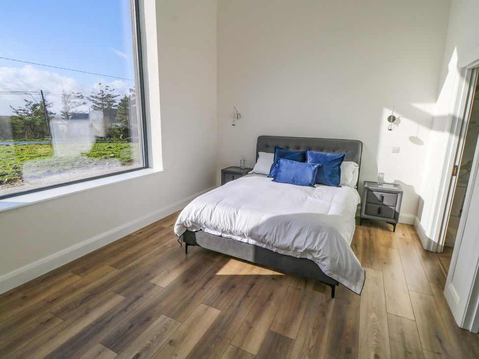 A bedroom with a bed and nightstands at An Tobar in Ballina