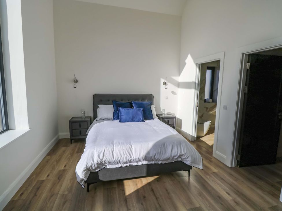 A bedroom with a bed and a bedside table at An Tobar in Ballina