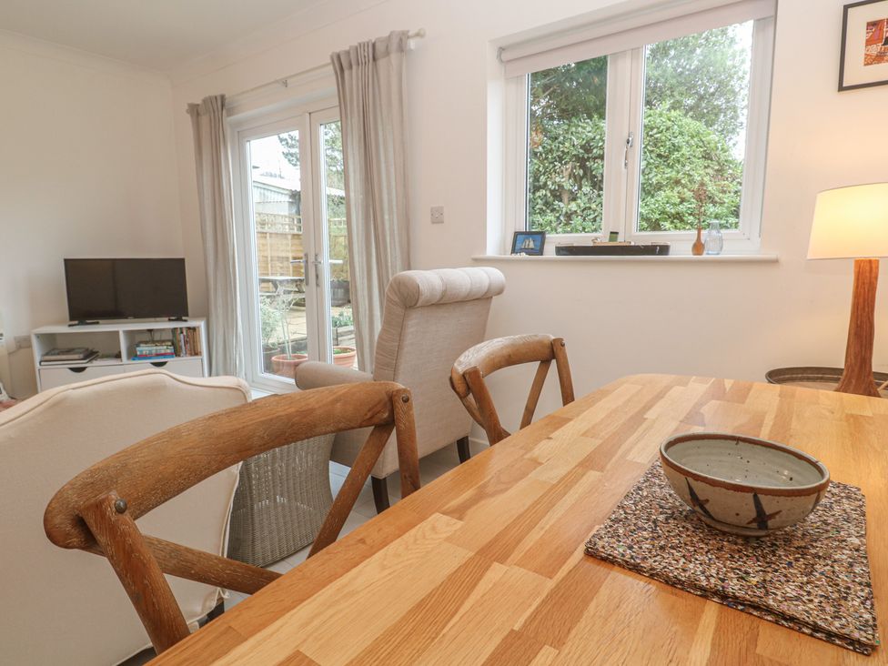 A dining room with a table and television at Pump Cottage in Truro