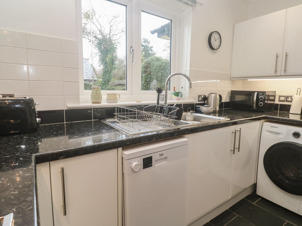 A kitchen with a sink and appliances at Pump Cottage in Truro