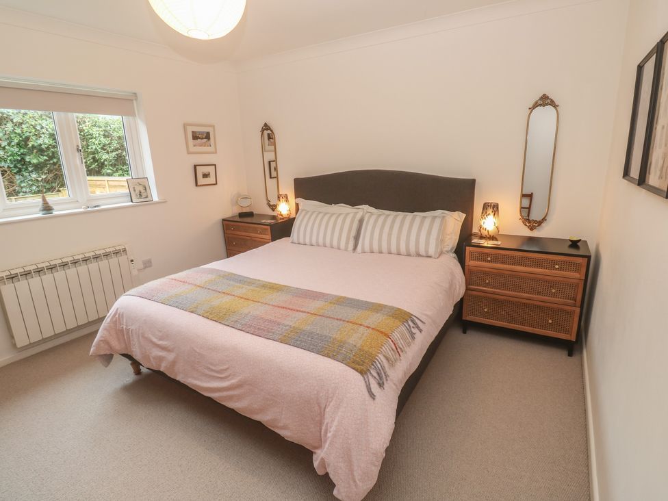 A bedroom with a bed and a dressing table at Pump Cottage in Truro