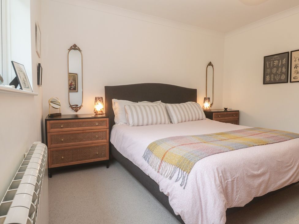 A bedroom with a bed and nightstands at Pump Cottage in Truro